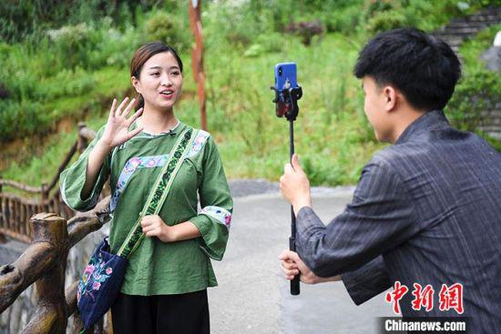 图为6月11日，施林娇正在进行直播，向网友推介十八洞。 中新社记者 杨华峰 摄