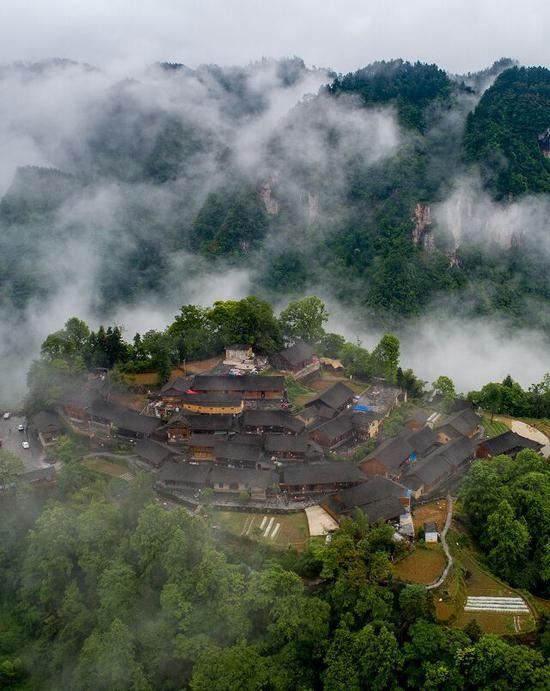 云遮雾绕下的十八洞梨子寨，晃如仙境一般。石林荣摄