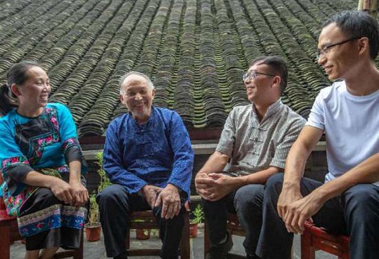  左二杨冬仕与村干部、村民们交谈。石林荣摄