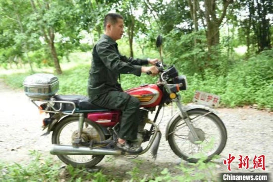 王首群驾驶护林摩托车开始一天的巡山护林工作。 林小丹 摄