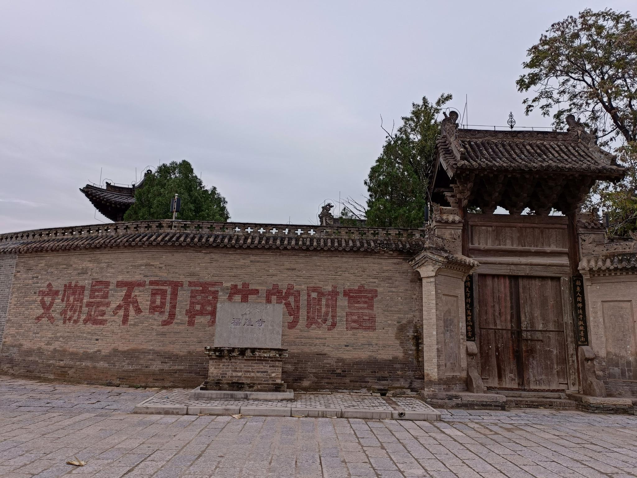光村国保文物福胜寺的围墙上写着:文物是不可再生的财富。新京报记者 吴采倩 摄