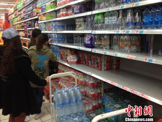 资料图:市民在超市里选购矿泉水。 窦跃文 摄